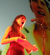 Die Brechungen der Inszenierung entstanden auch durch die Polyphonie von Live-Performance und medialer Einspielung (hier mit der Sopranistin Raphaela Stürmer). Foto: Frederik Busch